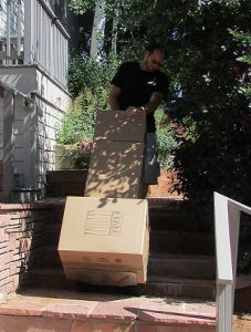 Crew member loading boxes down stairs